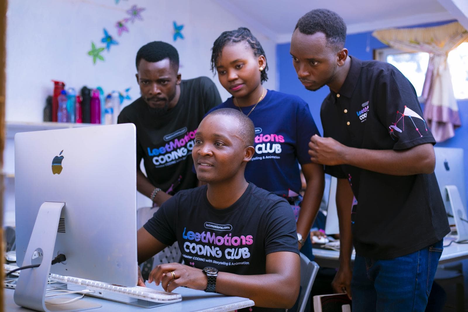 The LeetMotions team reviewing code together at an iMac