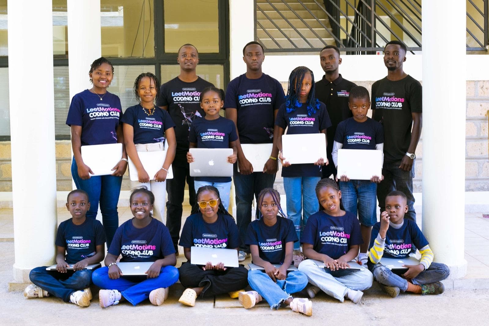 A large group of LeetCamp campers and instructors holding laptops outside